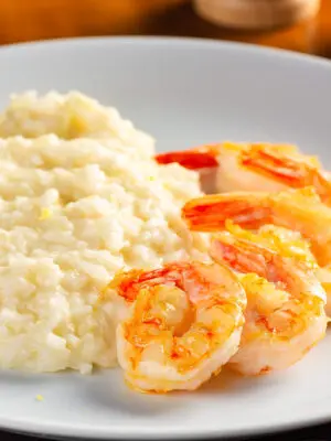 Camarão rosa grelhado com risoto de arroz negro e tomate confit